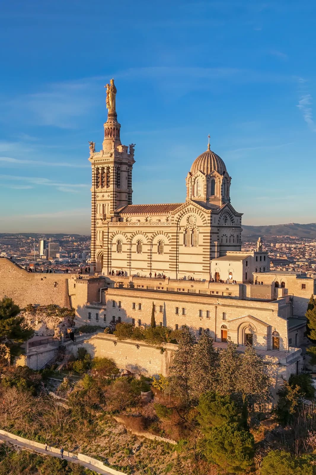 Die Basilika Notre-Dame-de-la-Garde im goldenen Licht der untergehenden Sonne, auf ihrem Hügel über Marseille